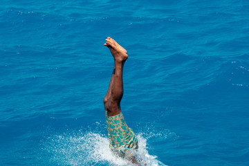 maldivian man diving from boat