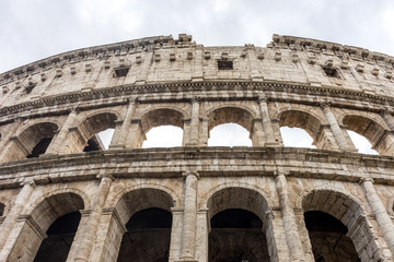 Facade of the Great Roman Colosseum (Coliseum, Colosseo), also known as the Flavian Amphitheatre. Famous world landmark. Scenic urban landscape.