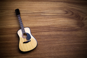 Fototapeta premium Acoustic guitar against an old wooden background.