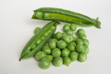 Many fresh green peas and two pods