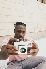 Young man holding an old analog camera