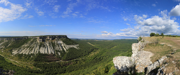 Fototapeta na wymiar From the height of the plateau Chufut-Kale in the Crimea, a beautiful panorama of the valley and the neighboring mountain of a similar structure