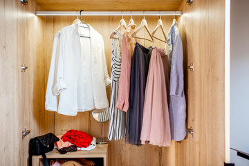 Wardrobe full of female clothes and shoes at home