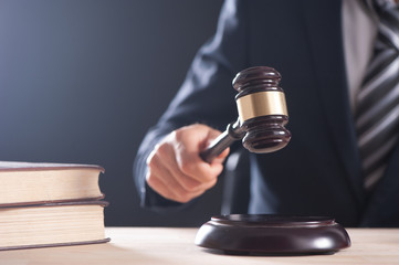 Hand of a judge holding a hammer or gavel
