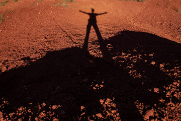 shadow of man in silhouette on red earth of Murgia, Alta Murgia National Park, Apulia, Italy