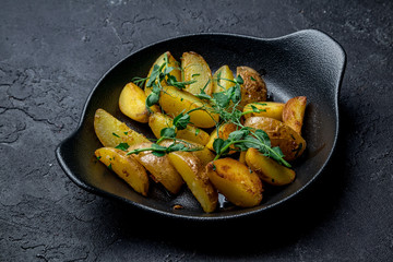 The potatoes wedges on a black plate