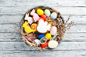 Easter colored cakes, decorative eggs and sweets. Greeting card On a white wooden background. Top view. free copying space.
