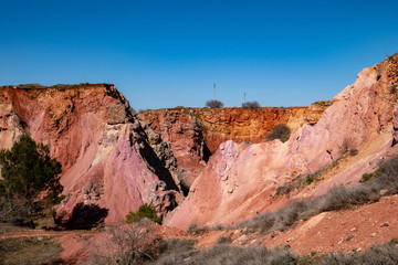 abandoned bauxite quarry in the land of Murgia with blue sky. Apulia, Italy