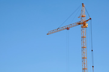 Construction crane on blue sky background