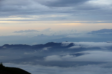 Obraz premium Clouds flowing over mountain tops, seen from Mount Fuji at dusk, Japan
