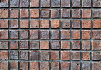 Muro de ladrillos cuadrados de diferentes tonos de rojo