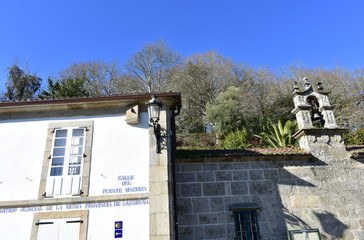 Ponte Maceira, Coruña, Spain. Wall with sundial, iron light and Camino de Santiago symbol. San...