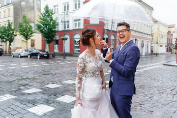 Naklejka premium bride and groom having fun outdoors in the rain