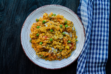 Lentil porridge with vegetables and herbs. Healthy lifestyle. Dietary menu. Dark wooden background. View from above.