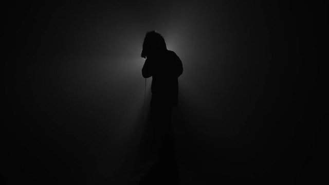 Silhouette of rapper performing with microphone