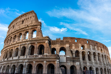 Fototapeta na wymiar Golden sunset at the Great Roman Colosseum (Coliseum, Colosseo), also known as the Flavian Amphitheatre. Famous world landmark. Scenic urban landscape.