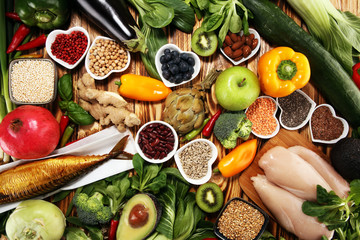 Healthy food clean eating selection. fruit, vegetable, seeds, superfood, cereals, leaf vegetable on rustic background