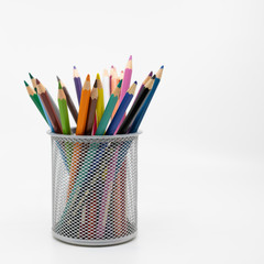 Metal pot containing colouring pencils
