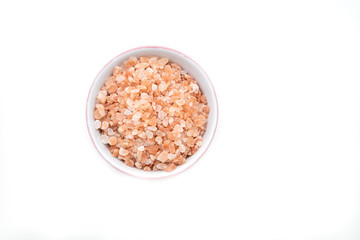 Bowl of pink himalayan salt on white background