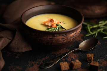Fish cream soup with Salmon, cheese, Potatoes and herbs in white Soup Bowls.