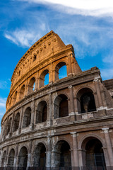 Fototapeta premium Golden sunset at the Great Roman Colosseum (Coliseum, Colosseo), also known as the Flavian Amphitheatre. Famous world landmark. Scenic urban landscape.