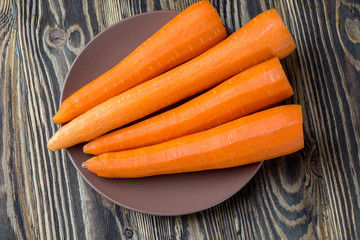 Peeled fresh carrots on rustic wooden table