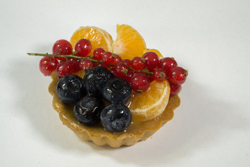 Cupcake with fresh bio fruit, orange, blueberry, red currant, side view photo, white background, isolate