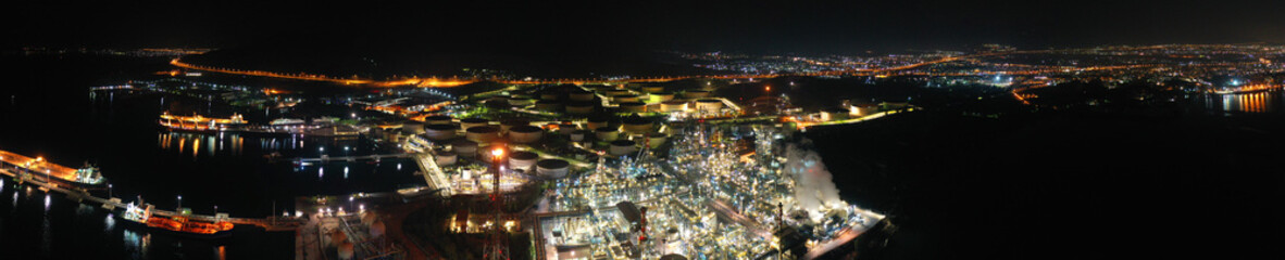 Fototapeta premium Aerial drone night shot of industrial oil refinery plant with dazzling lights