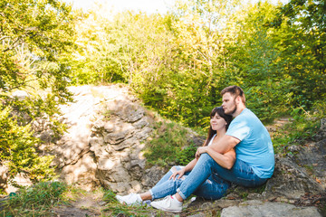 couple sitting and hugging in forest