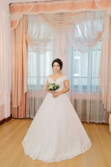 Fototapeta na wymiar Beautiful bride in a gorgeous dress and bouquet.