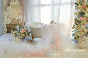 Bath on lion's Golden paws. The atmosphere of romance and love. Light interior, chiffon, flowers.