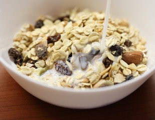 Cereal muesli in brown bowl with and milk