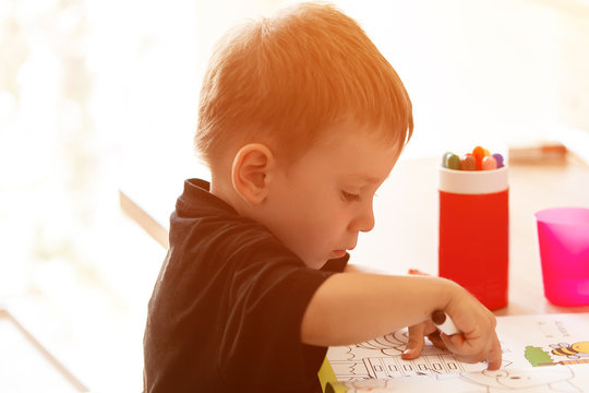 Happy smiling kid boy painting with pen. Kids Educational Concept.