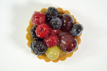 Cake with fresh bio fruits, grapes, raspberries, blackberries, top view photo, white background, isolate