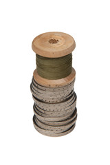 Rows of coins isolated on white background next to multicolored thread on wooden spool