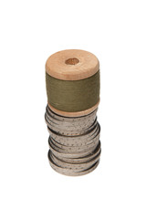 Rows of coins isolated on white background next to multicolored thread on wooden spool