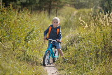 Toddler riding a balance bike along the path in the park