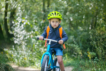 Toddler riding a balance bike along the path in the park