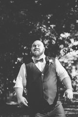 Fototapeta na wymiar Stylish bearded fat groom in the park.