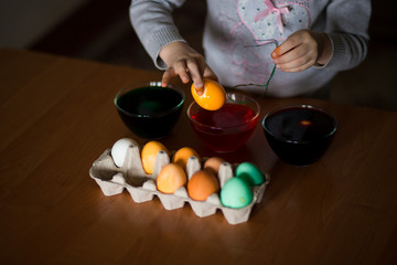 Obraz na płótnie Canvas Happy easter. Little girl painter painted eggs. Kid preparing for Easter. Painted hand. Art and craft concept. Traditional spring holiday food