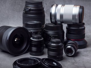 Professional camera lenses on a grey background.