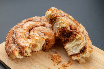 Tasty cookie broken in half. Fresh bread on a kitchen board.