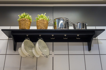 Some kitchenware hang on white brick wall