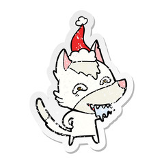 distressed sticker cartoon of a hungry wolf wearing santa hat