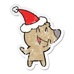 laughing bear distressed sticker cartoon of a wearing santa hat