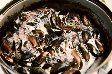 Mussels are fried in a skillet. Cooking in the kitchen. Seafood. asian food