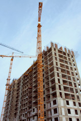 Fototapeta na wymiar Construction site with high cranes against blue sky. Construction of a new residential building.