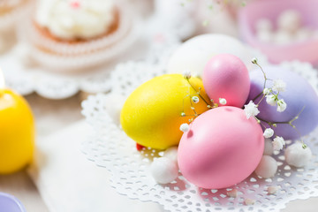 Easter eggs in pastel color on a white cake stand. Festive  light background