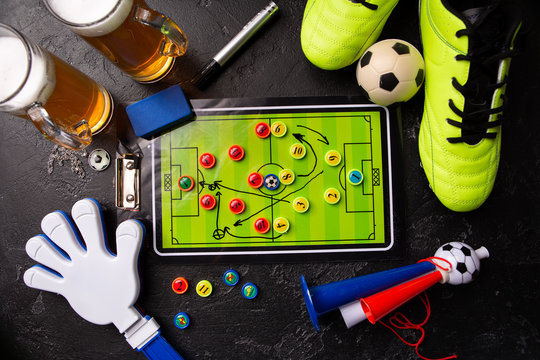 Photo on top of two mugs of foam beer, table football, ball, football boots, pipe, rattle toy