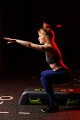 Side photo of sporty woman crouching at step.